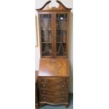 A small reproduction mahogany bureau bookcase, with two glazed doors over drop front, fitted