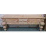 A modern limed pine console table with two drawers flanked by two doors with baluster shaped