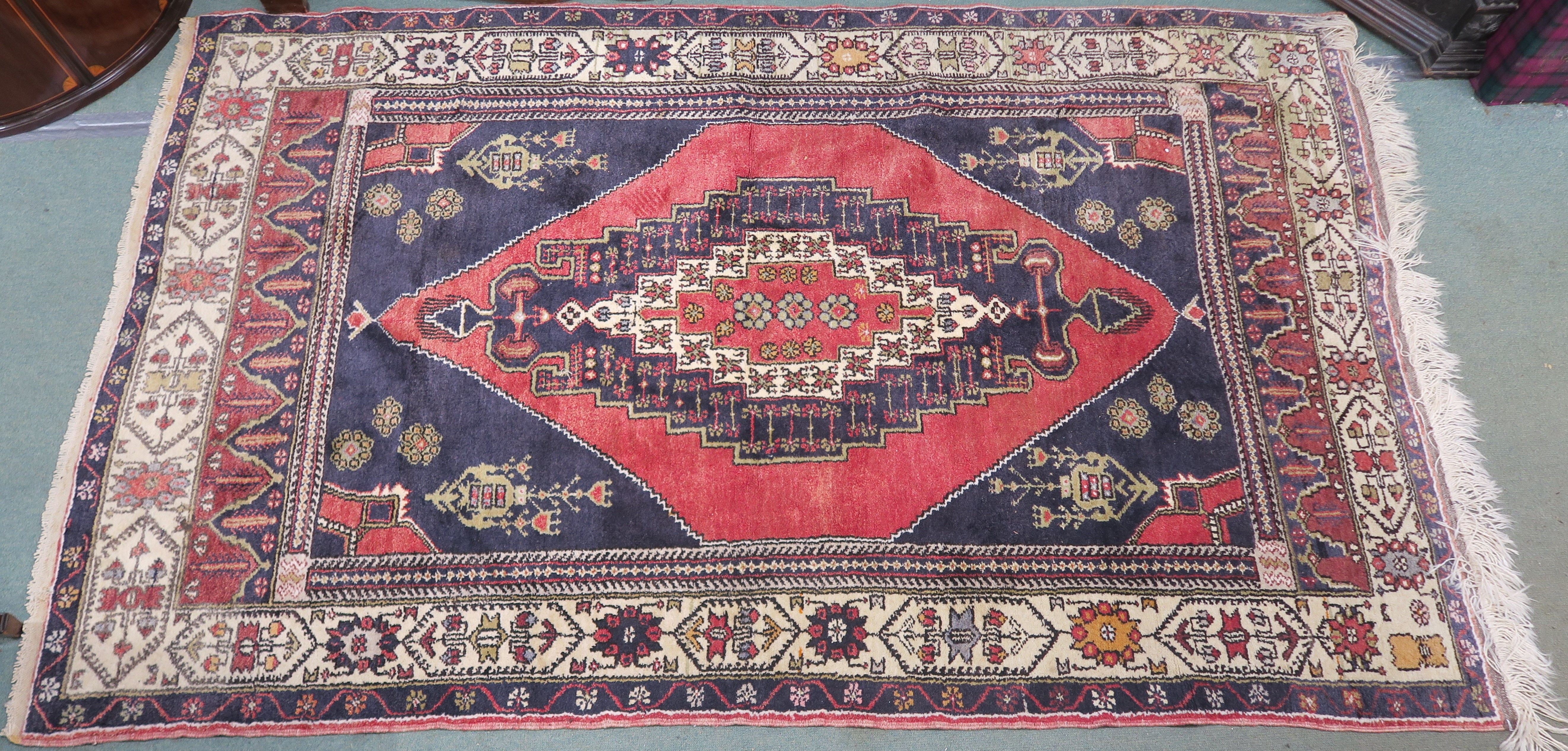 A blue ground Turkish Anadol wool rug with geometric design within a cream border, 250cm x 156cm