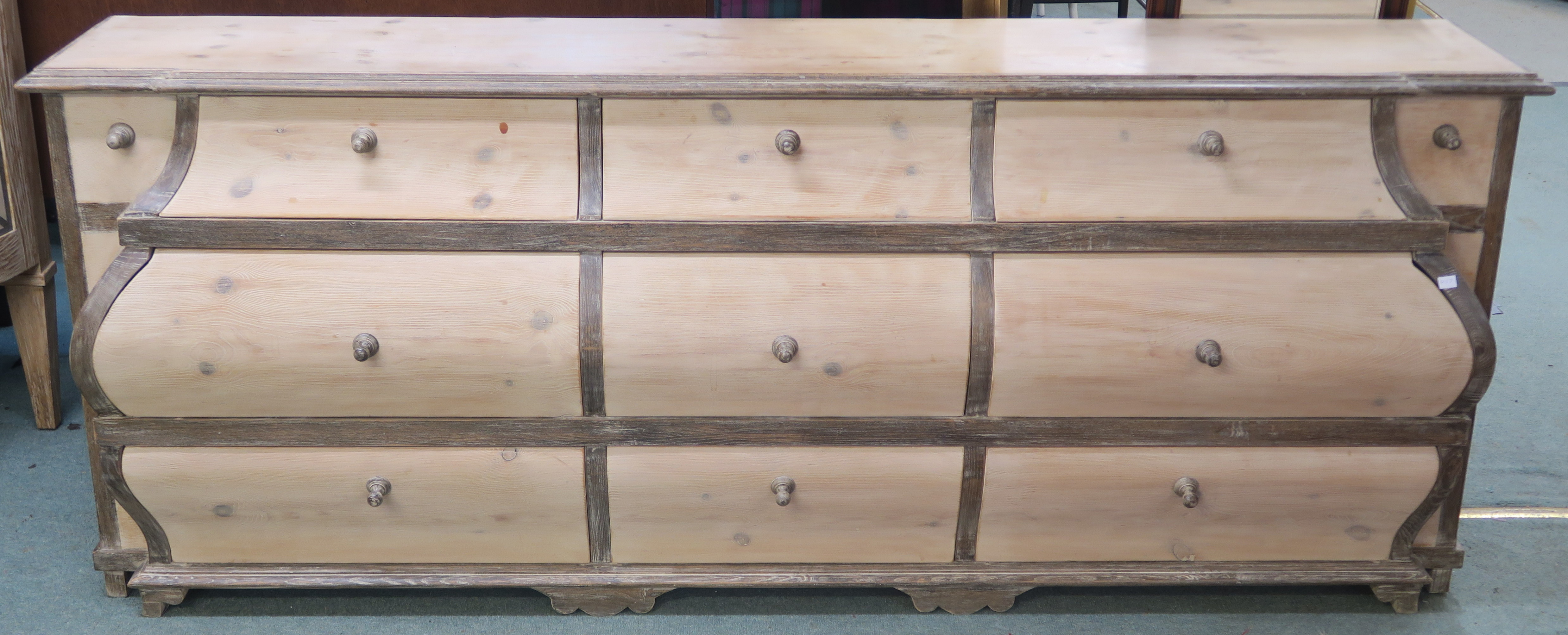 A modern limed pine bombe shaped sideboard with nine drawers, retailed by Design Works, Interior