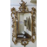 A reproduction ornate gilt wall mirror, 105cm x 57cm Condition Report: Available upon request