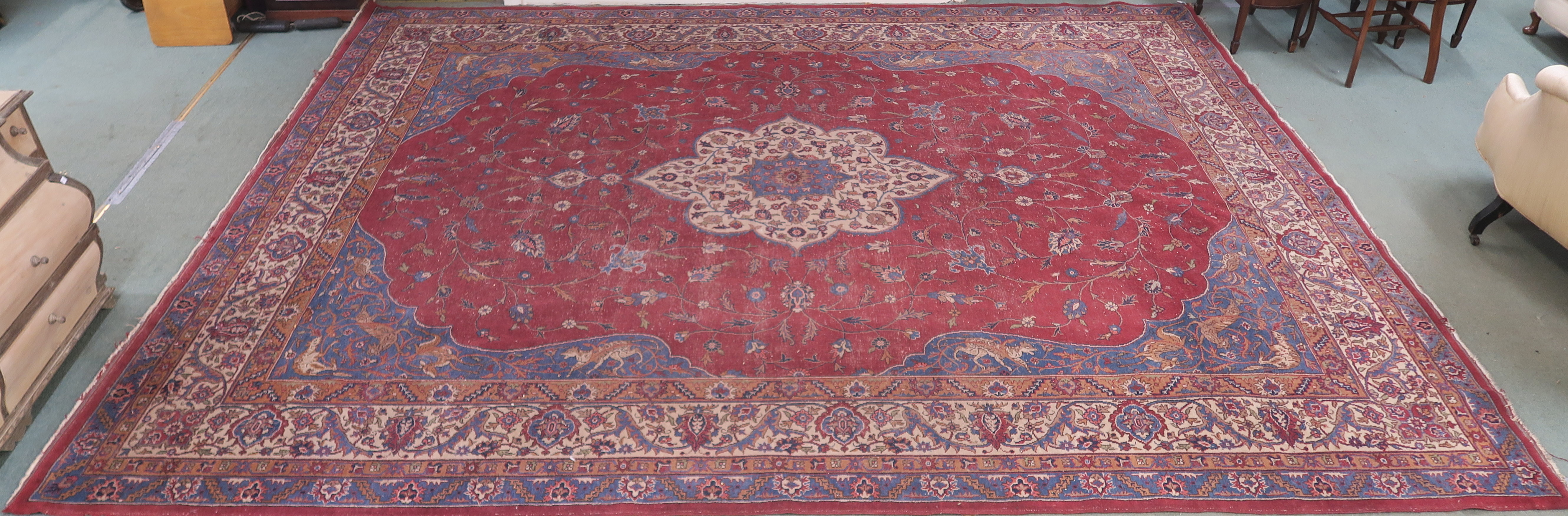 A large Turkish tabriz rug, red ground with central medallion and spandrels with animals and birds