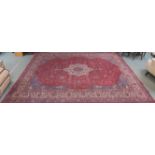 A large Turkish tabriz rug, red ground with central medallion and spandrels with animals and birds