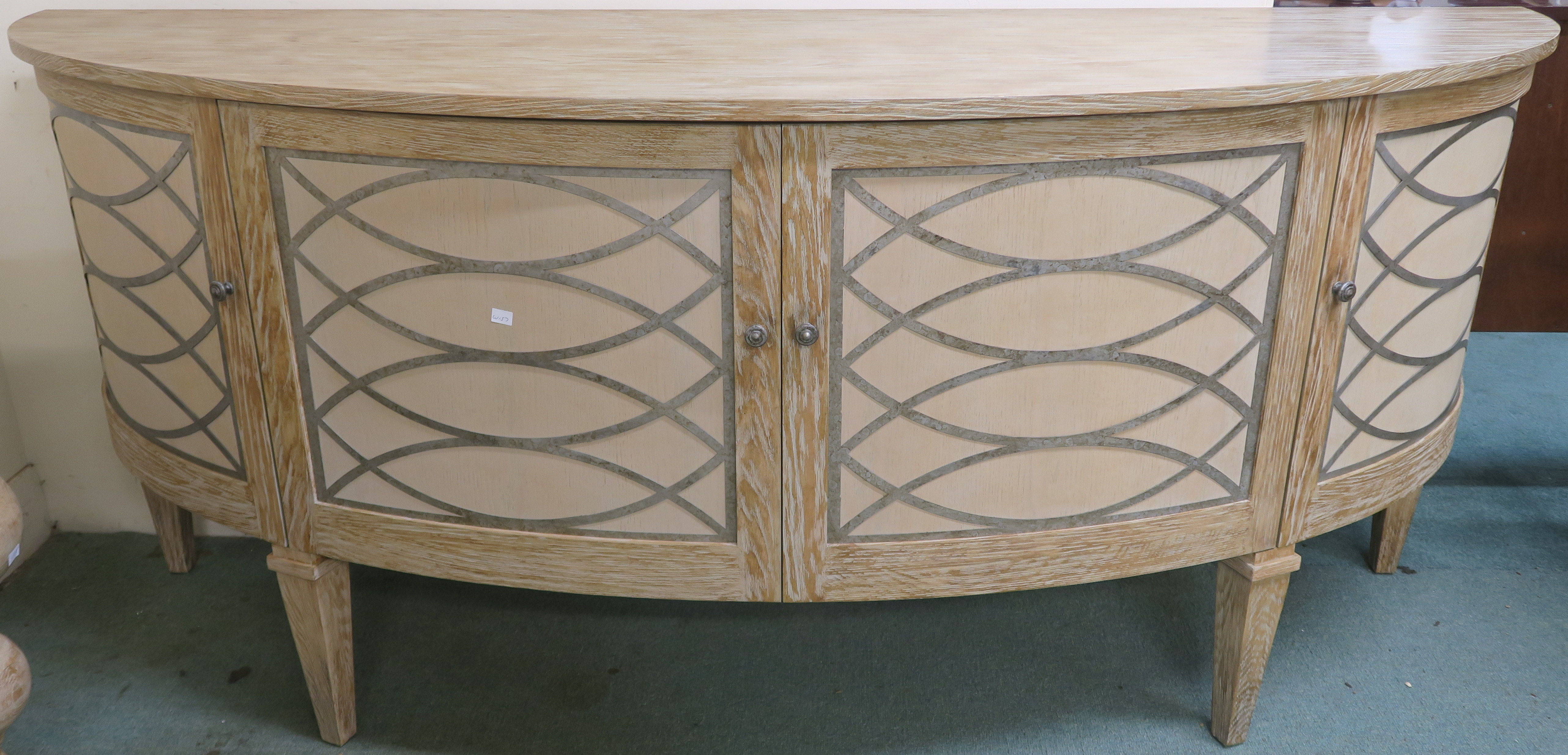 A modern limed pine bow front sideboard with four doors with the top having a textured finish with