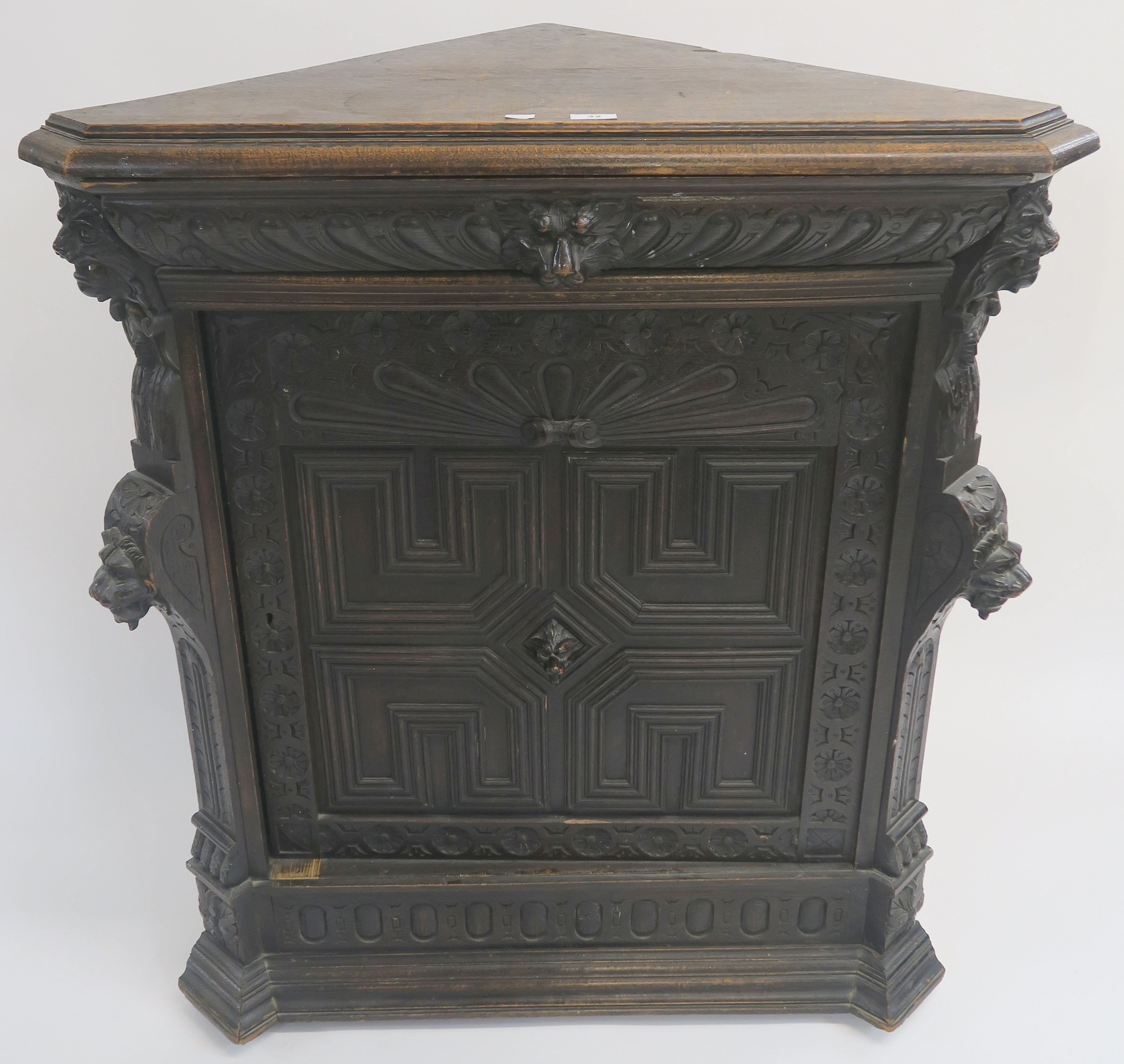 A Continental oak corner cabinet with single carved frieze drawer with mask handle over a carved