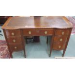 A mahogany writing desk with rexine skiver with central drawer flanked by six bow front drawers on