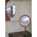 A circular tilting mirror on turned support on shaped base, 55cm high x 33cm diameter and a