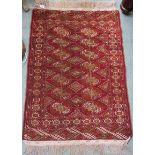 A red ground Turkeman style rug, 114cm x 80cm Condition Report: Available upon request