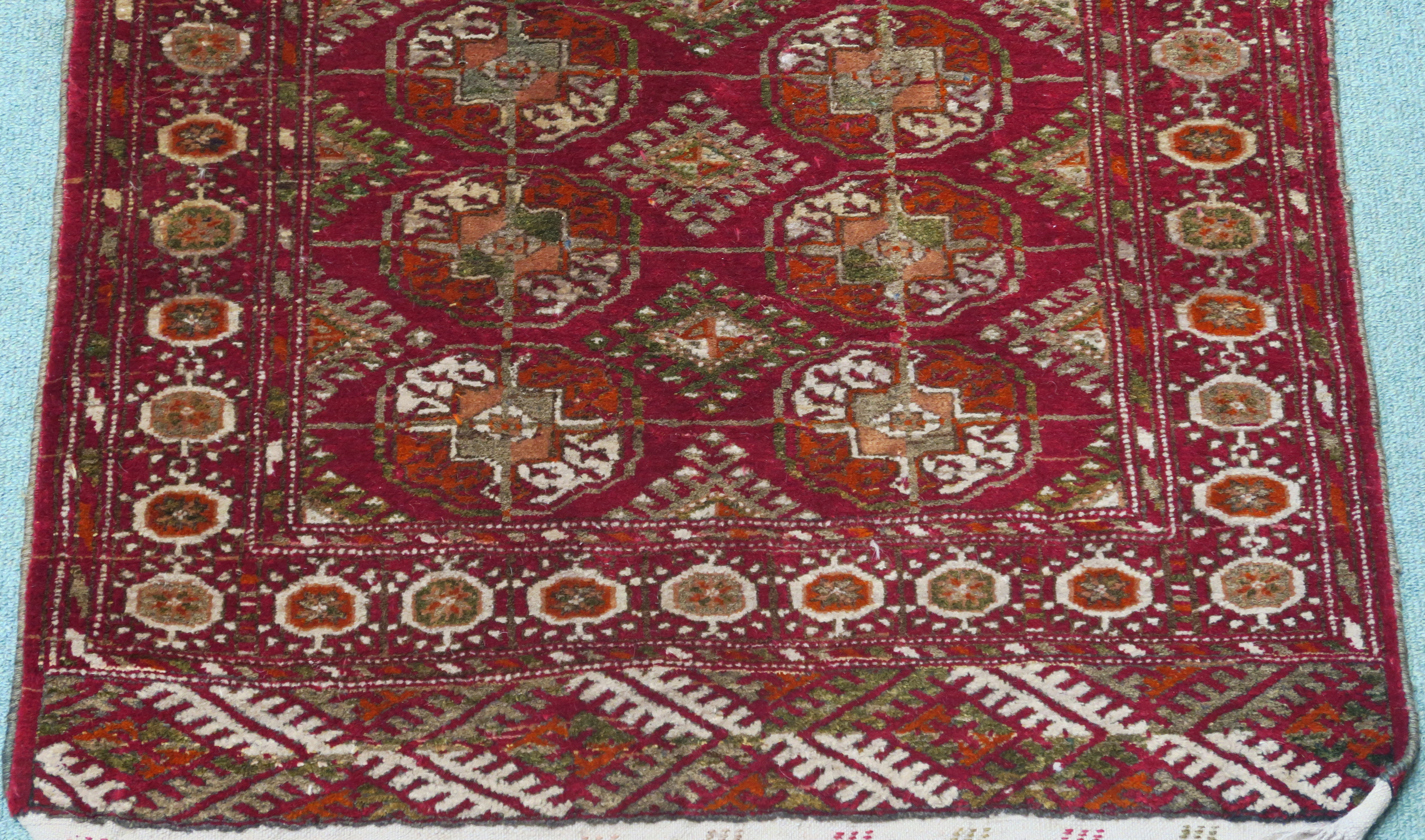 A red ground Turkeman style rug, 114cm x 80cm Condition Report: Available upon request - Image 2 of 3