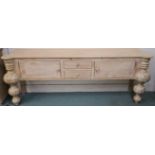 A modern limed pine console table with two drawers flanked by two doors with baluster shaped