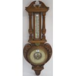 A Victorian carved oak thermometer/barmometer, 101cm high Condition Report: Available upon request