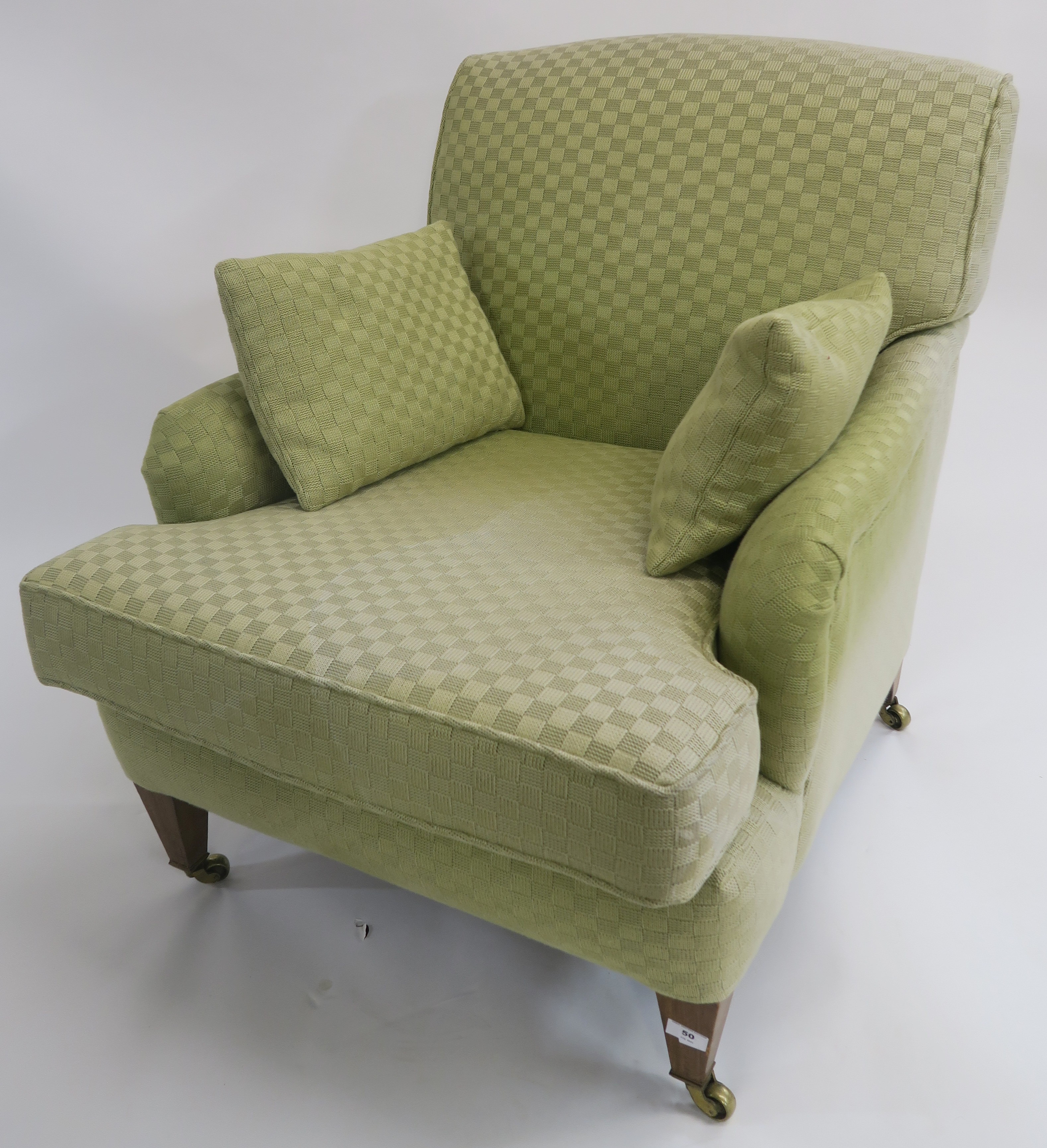 A green upholstered armchair on square tapering legs with brass castors, 84cm high Condition Report: