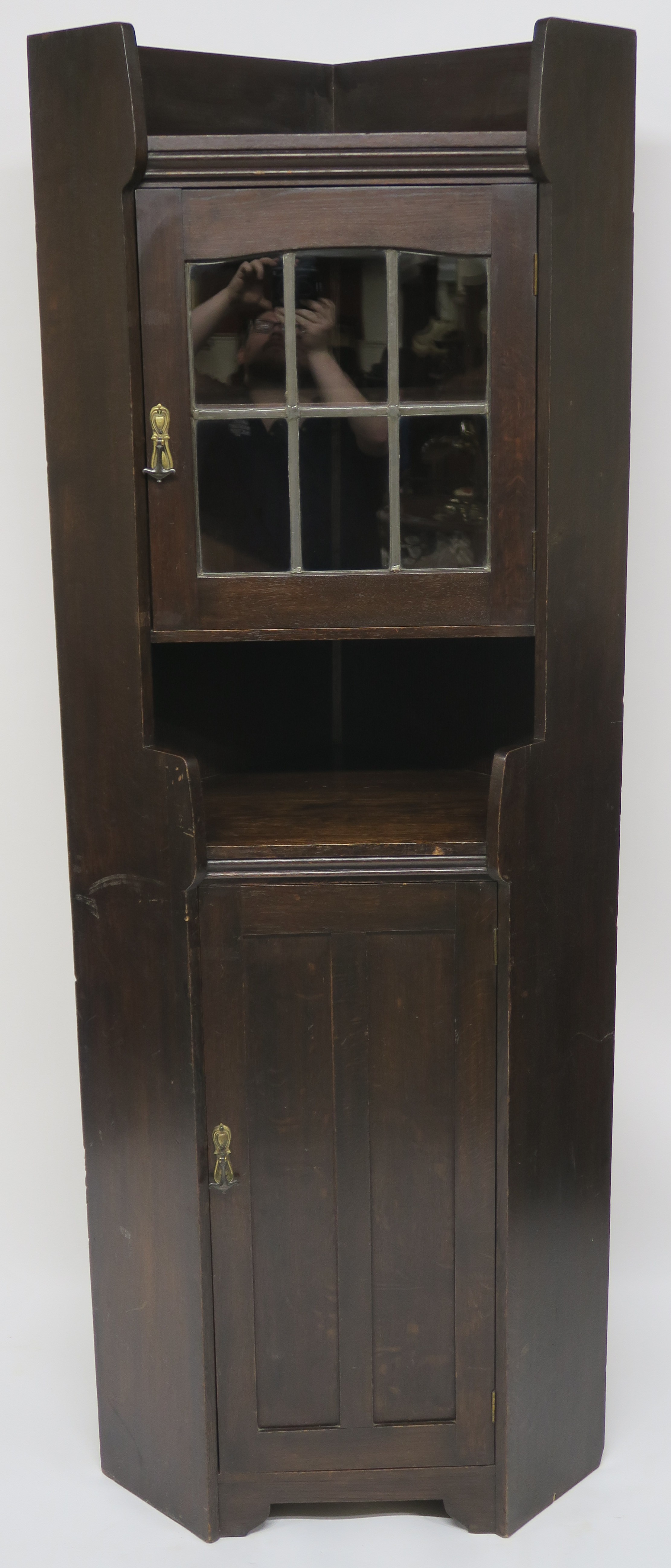 A Liberty & Co oak corner cabinet, the upper section having leaded glazed door over open shelf on