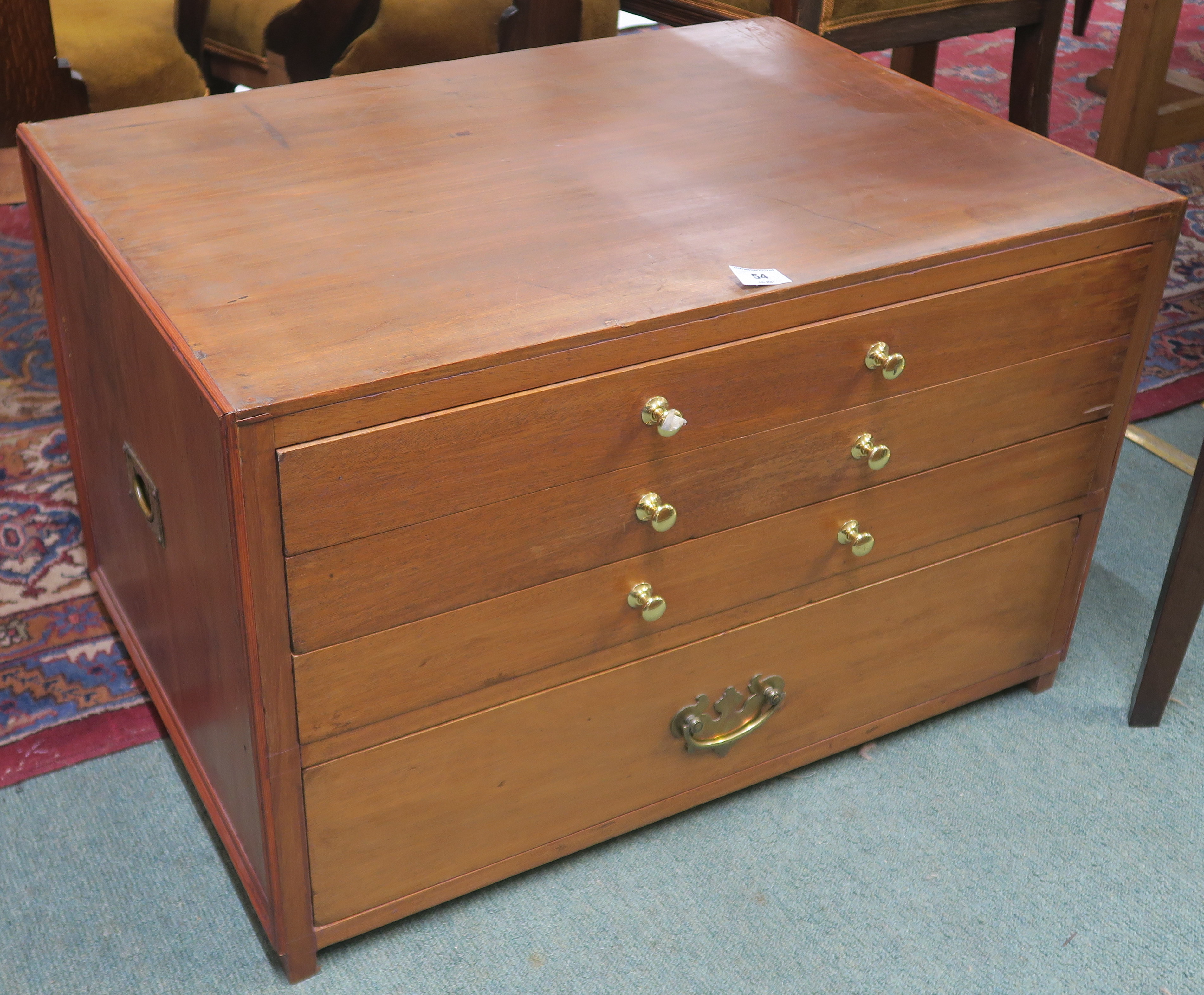 A teak and pine collectors cabinet with four drawers and brass campaign style brass side handles,