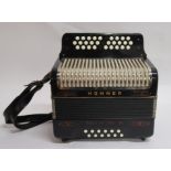 A Hohner Trichord III three row melodeon, in black with case. The 32 melody buttons with 12