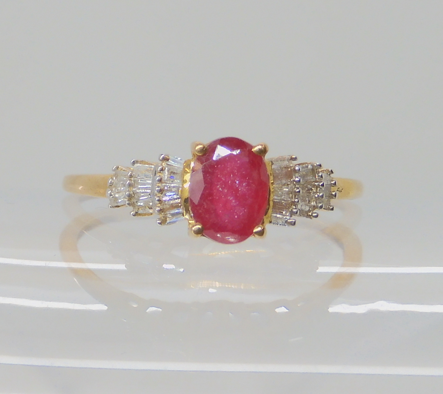 A 9ct gold ruby and baguette cut diamond ring, size V1/2, weight 2gms Condition Report: Available