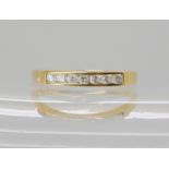 An 18ct gold seven stone band ring, set with estimated approx 0.25cts of brilliant cut diamonds.