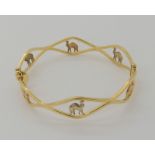 An 18ct three colour gold bangle with camel design. Inner diameter 5.5cm x 5.6cm, weight 8.2gms