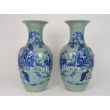 A PAIR OF CHINESE CELADON GROUND VASES each moulded and painted in blue with Buddhist figures,