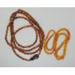 A STRING OF AMBER BEADS AND A STRING OF HORN BEADS the yellow amber beads are 74cm long, the largest