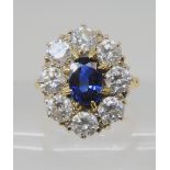A SUBSTANTIAL SAPPHIRE AND DIAMOND CLUSTER RING with 18ct gold mount, the central sapphire