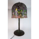 A LARGE LEADED AND STAINED GLASS TABLE LAMP the metal tree trunk body supporting a flower