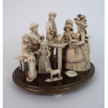 A 19th CENTURY CONTINENTAL IVORY FAMILY GROUP modelled as men and woman sat around a table, set with