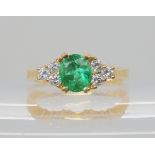 AN EMERALD AND DIAMOND RING mounted in bright yellow metal, emerald approx 7.7mm x 6.7mm x 5.9mm,