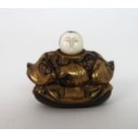 A JAPANESE LACQUERED NETSUKE FIGURE seated and wearing elaborate gilt costume, 2.5cm high