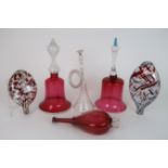 A COLLECTION OF NAILSEA GLASS including two cranberry glass bells, two clear and red mottled flasks,