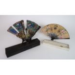 *WITHDRAWN* A CANTON BLACK LACQUERED AND PAINTED BRISE FAN painted with courtesans before pagodas