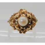 A BRIGHT YELLOW METAL CONTINENTAL ART NOUVEAU STYLE RING the single pearl surrounded by flower