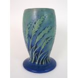 A MOORCROFT FOOTED VASE decorated with wheat on a ribbed blue and green ground, with blue