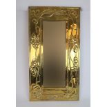 A SCOTTISH ARTS AND CRAFTS BRASS FRAMED MIRROR of rectangular shape, with relief decoration of
