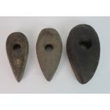 THREE ANCIENT BRITISH STONE CARVED AXE HEADS 22cm, 25cm and 21cm long The estate of The late