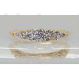A FIVE STONE DIAMOND RING WITH SCROLLED MOUNT the shank stamped 18, possibly continental, the