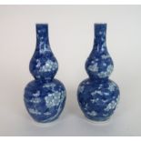 A PAIR OF CHINESE BLUE AND WHITE DOUBLE GOURD VASES painted with blossoming branches, painted four