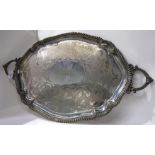 A silver plated twin handled serving tray with central cartouche monogrammed "DMCC" 78 cm across the