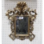 A Rococo style giltwood bevelled wall mirror, the frame modelled as scrolling acanthus leaves and