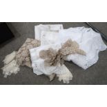 A quantity of embroidered, crochet table linen and covers including floral embroidered examples,