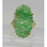 AN 18CT GOLD CHINESE GREEN HARDSTONE CHRYSANTHEMUM RING the pierced and carved panel measures approx