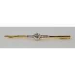 A YELLOW METAL DIAMOND BAR BROOCH set with an estimated approx 0.40ct brilliant cut with further old
