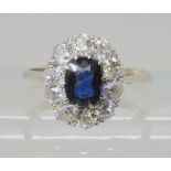 A SAPPHIRE AND DIAMOND CLUSTER RING set with an oval sapphire 7mm x 5mm, surrounded with old cut