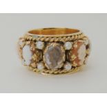 A 14K GOLD SUBSTANTIAL CAMEO SPECIMEN RING the wide band set with eight cameos interspaced with