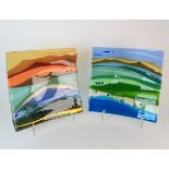 •SCOTT IRVINE (b. 1970) - TWO FUSED GLASS LANDSCAPE PANELS each with a stand, 39cm x 39cm