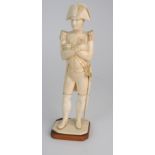 A LATE 19TH/EARLY 20TH CENTURY CARVED IVORY MODEL OF NAPOLEON in uniform with crossed arms, on