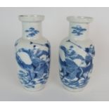 A PAIR CHINESE BLUE AND WHITE BALUSTER VASES painted with warriors astride mythical beasts,