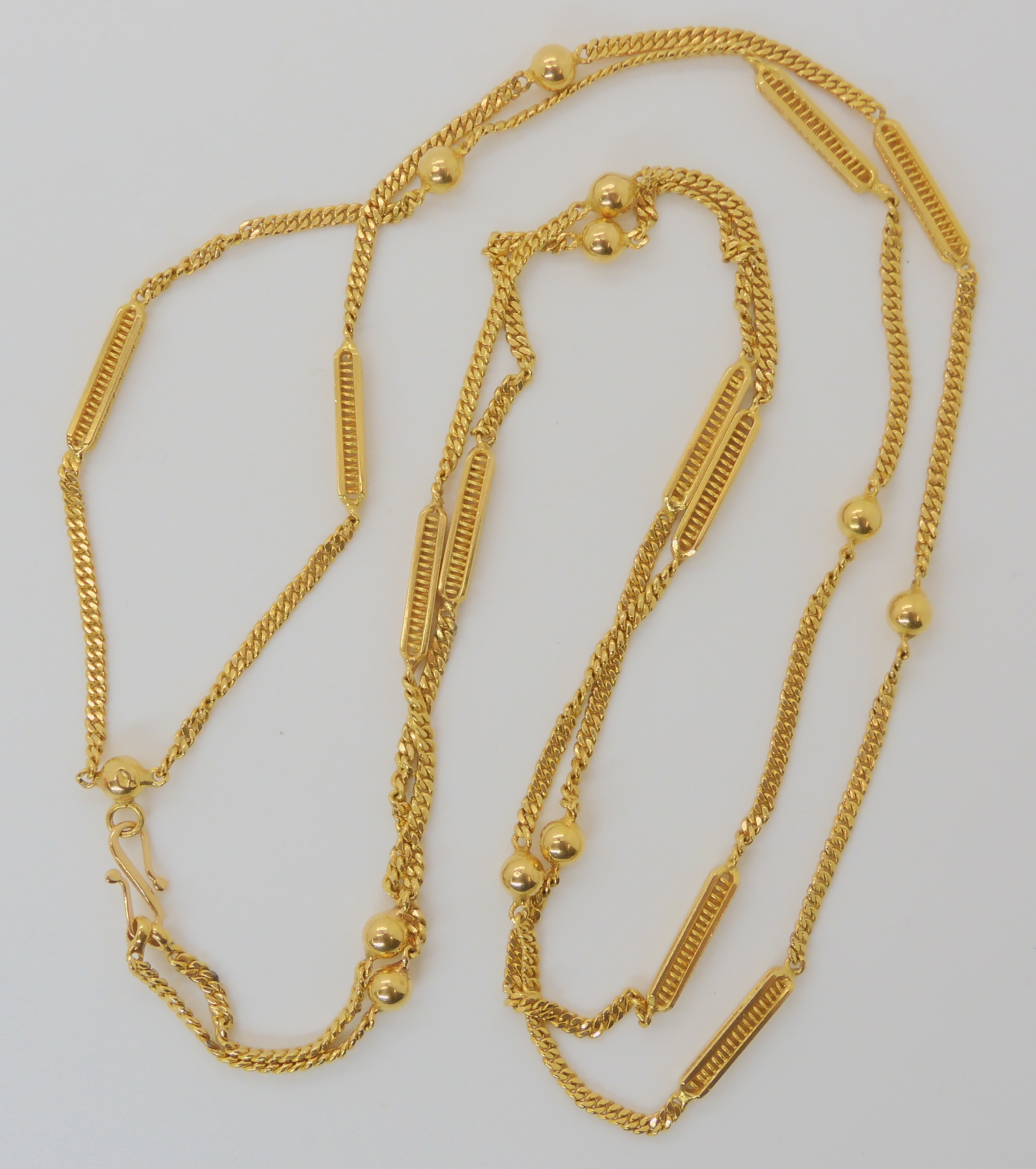 A BRIGHT YELLOW METAL DOUBLE LENGTH FANCY CHAIN with ball and fancy baton links, can be worn in