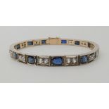 A BLUE AND WHITE SAPPHIRE BRACELET mounted in yellow and white metal with decorative engraving to