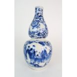 A CHINESE BLUE AND WHITE DOUBLE GOURD SHAPED VASE painted with panels of figures in conversation